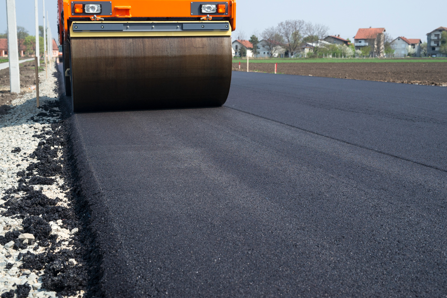 Roller laying a smooth fresh asphalt surface on a rural road