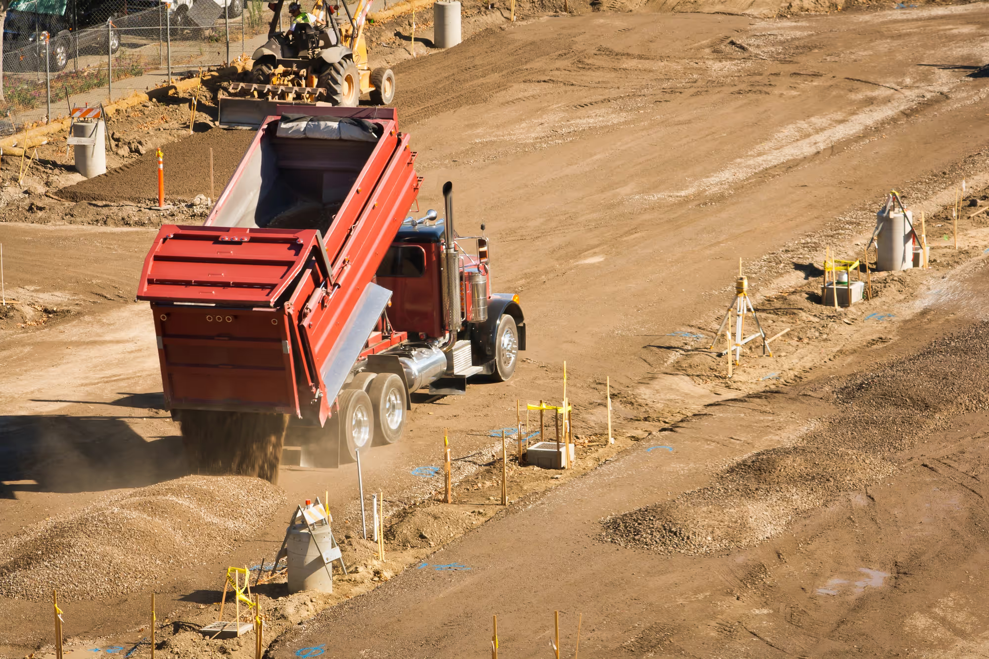 Dump truck delivering sand and gravel to a job site